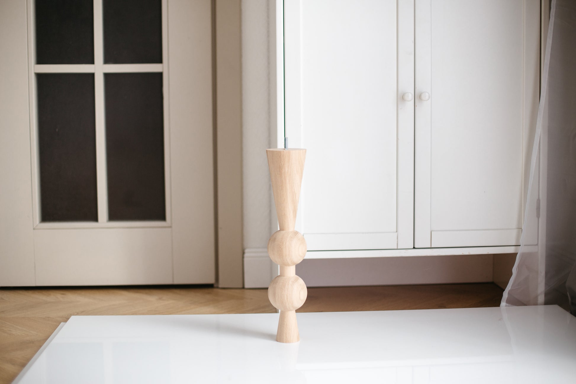 Wooden candle holder on a white surface with a neutral background