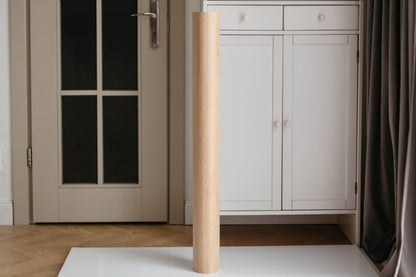 Wooden leg of a piece of furniture against a neutral background