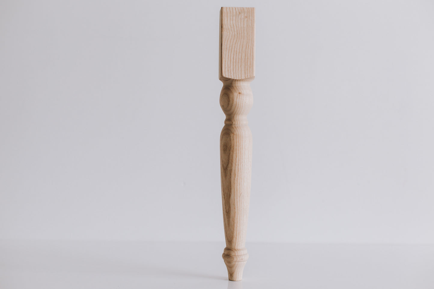 Wooden leg on a light gray background